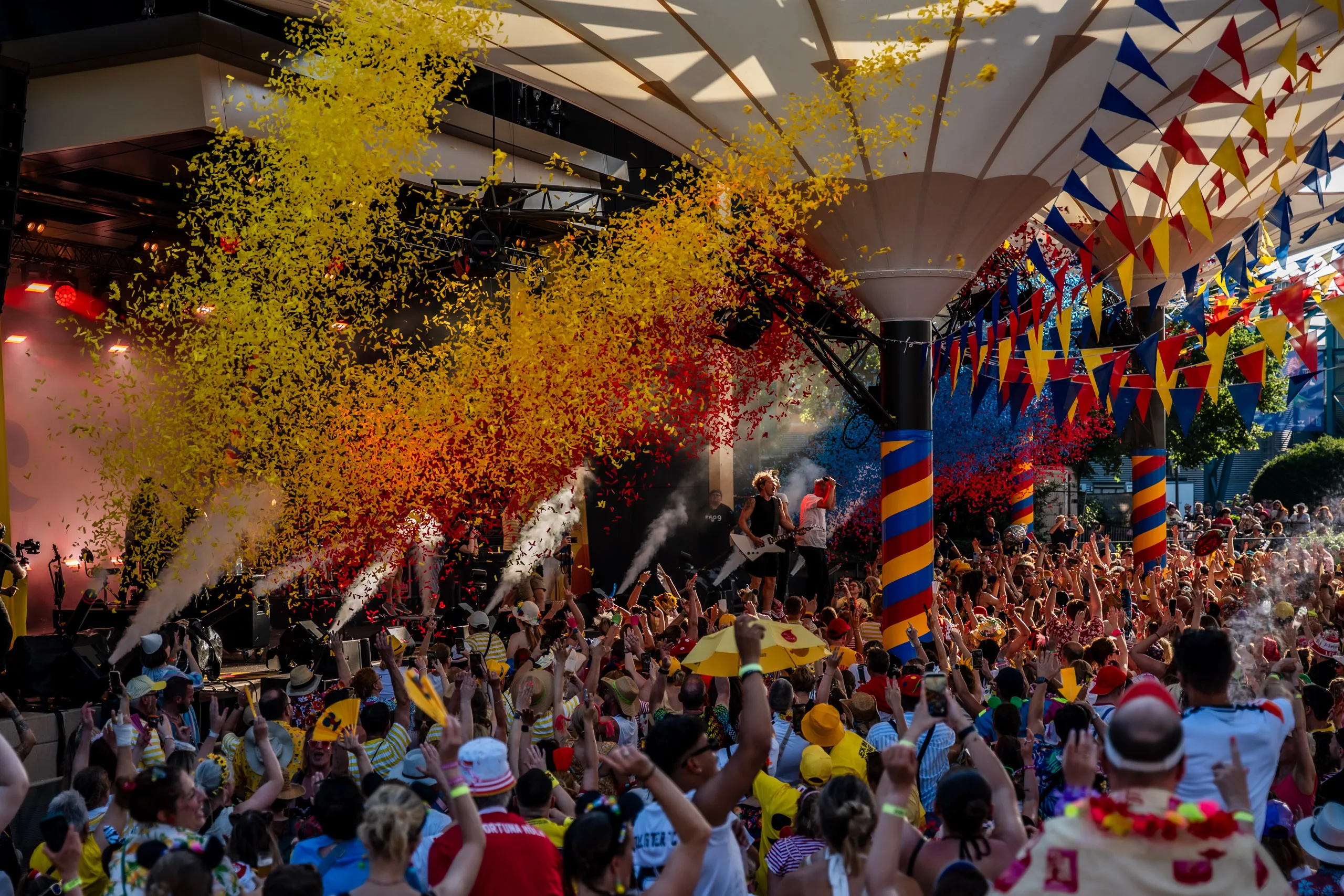 A burst of yellow and red confetti above the cheering crowd at Jeck im Sunnesching at the Tanzbrunnen in Cologne.