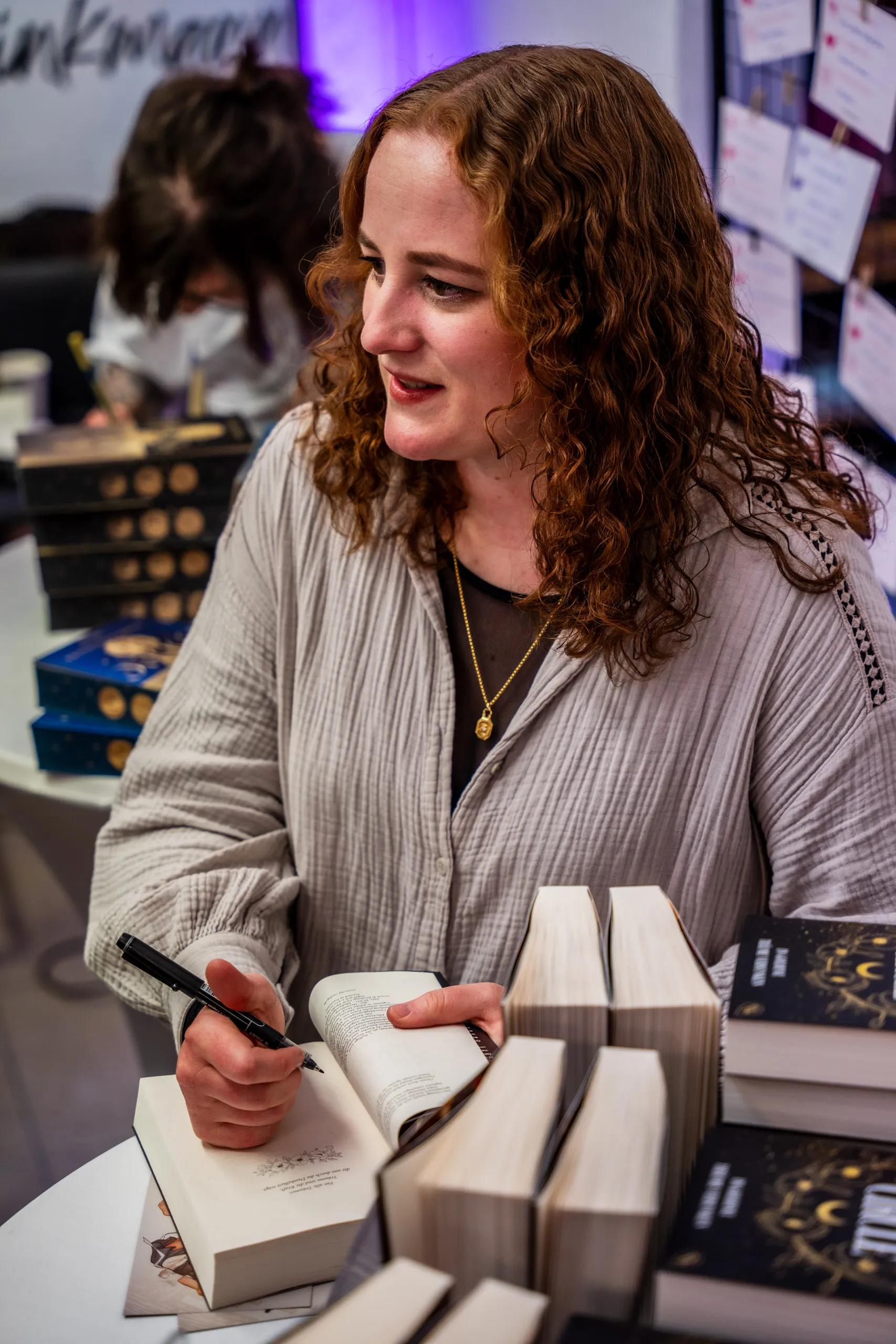 Caroline Brinkmann signing her books at the table, Nicole Böhm signing in the background.