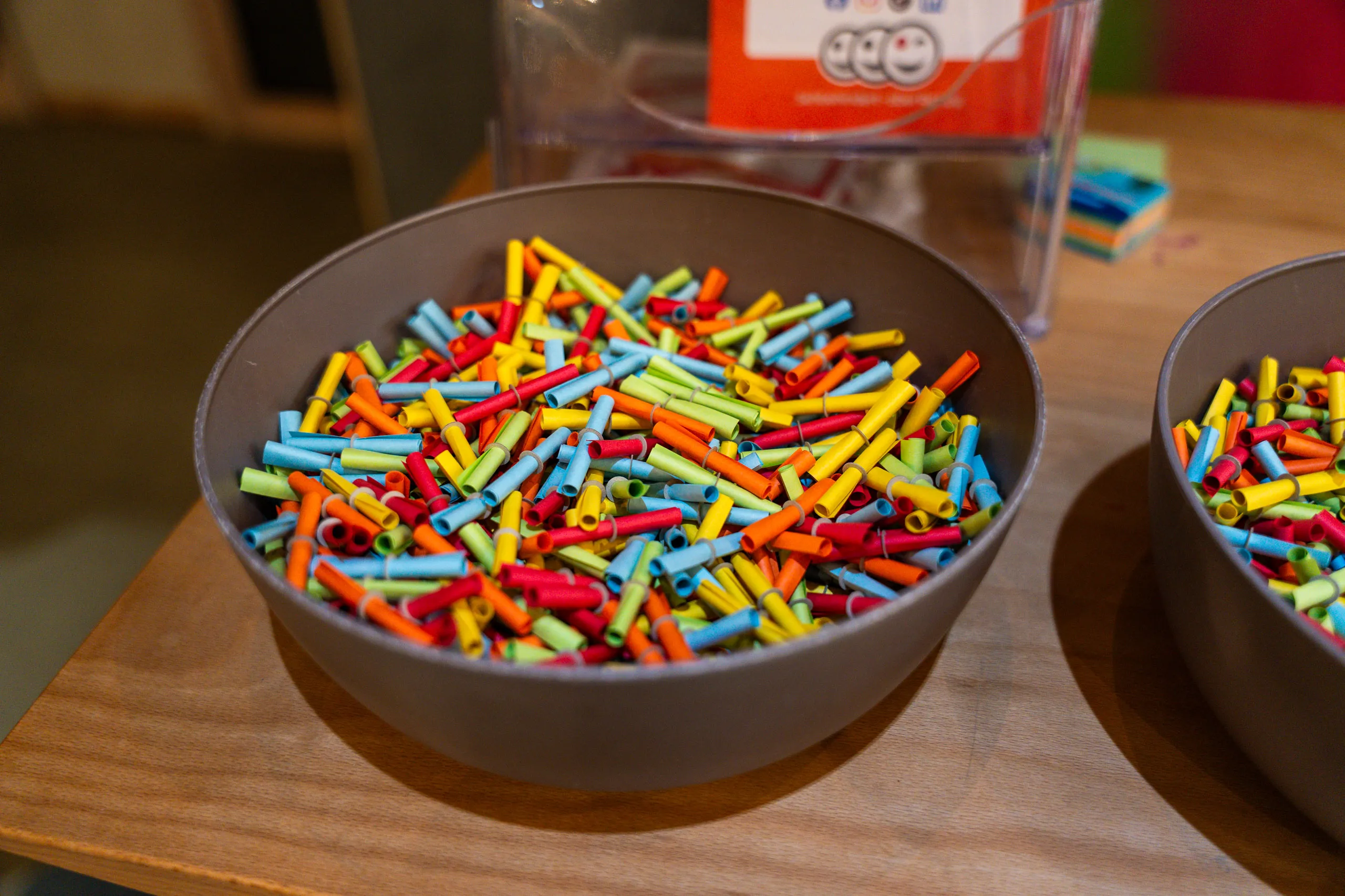 Colourful rolled-up raffle tickets in two bowls at the tombola stand of the bazaar.